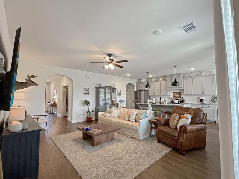 Living area featuring ceiling fan, dark wood-style floors, arched walkways, and recessed lighting Living area featuring ceiling fan, dark wood-style floors, arched walkways, and recessed lighting