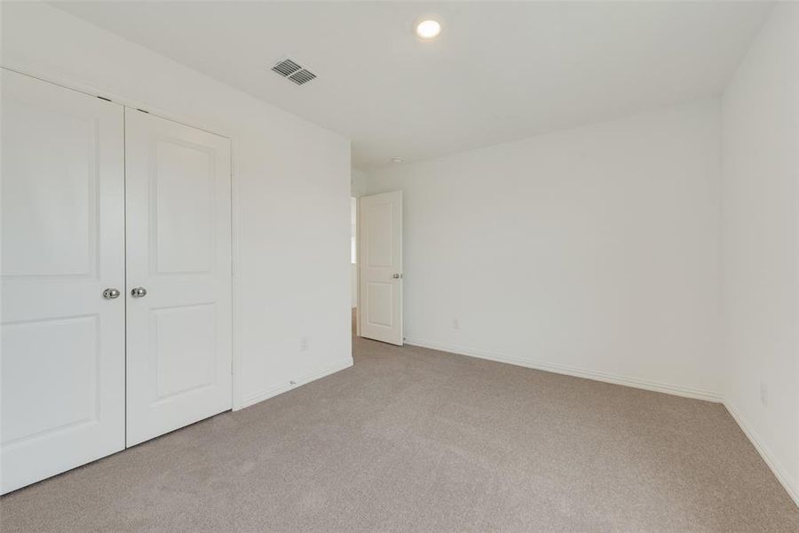 Unfurnished bedroom with a closet and light colored carpet