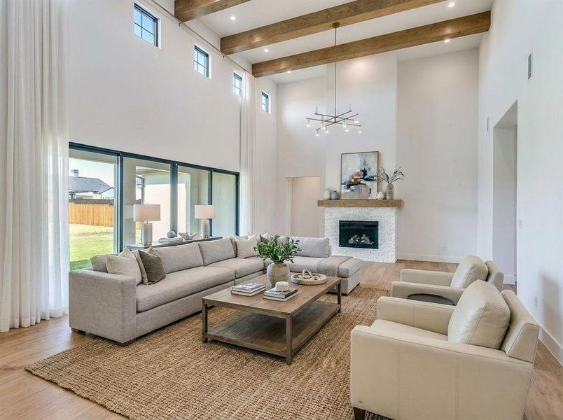 Virtual Staged Unfurnished living room featuring light wood finished floors, beamed ceiling, and a high ceiling Virtual Staged Unfurnished living room featuring light wood finished floors, beamed ceiling, and a high ceiling