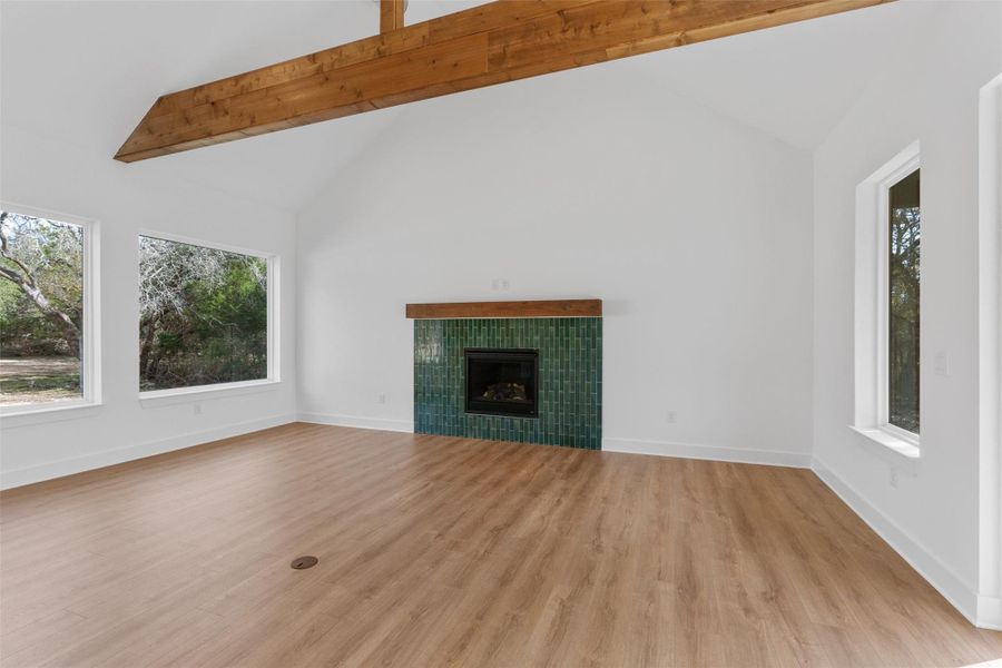 Open living room with vaulted, beamed ceilings and walls of windows that bring in abundant natural light and peaceful outdoor views. Open living room with vaulted, beamed ceilings and walls of windows that bring in abundant natural light and peaceful outdoor views.