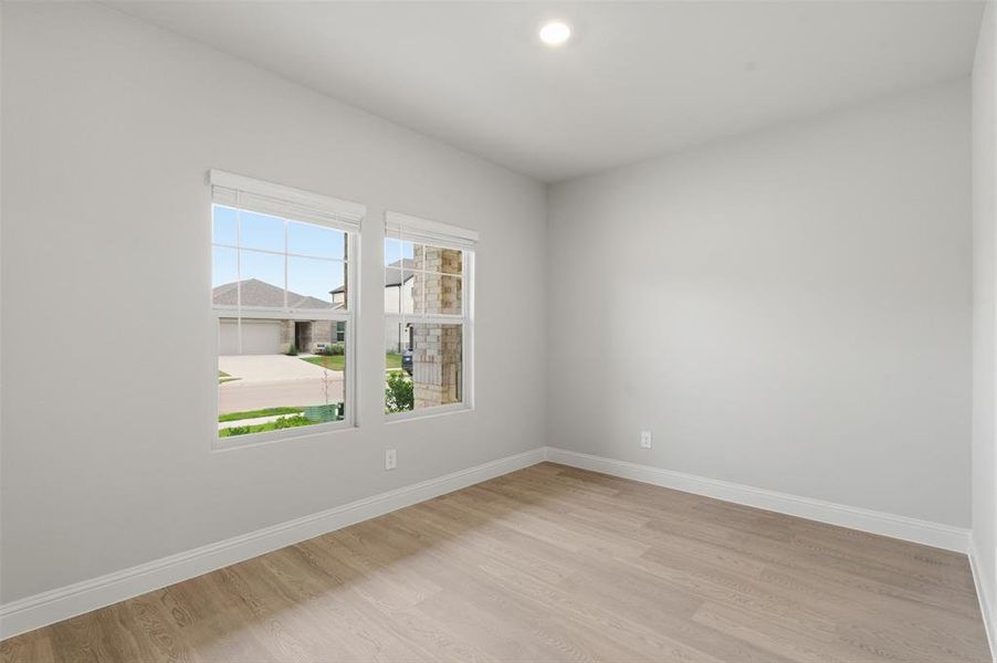 This room features light-colored walls, recessed lighting, and two windows