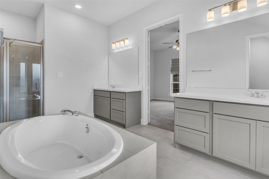 Relax in your primary bath with double vanity sinks, soaker tub, and standing showing.