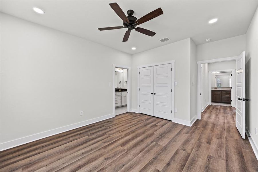 Unfurnished bedroom with connected bathroom, dark wood-style floors, a closet, recessed lighting, and a ceiling fan Unfurnished bedroom with connected bathroom, dark wood-style floors, a closet, recessed lighting, and a ceiling fan