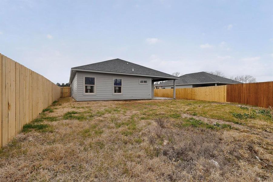Back of property with a patio area, a fenced backyard, and a shingled roof