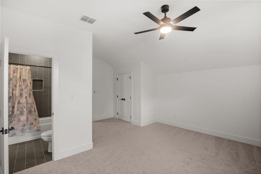Bonus room featuring lofted ceiling, a ceiling fan, carpet floors, and baseboards Bonus room featuring lofted ceiling, a ceiling fan, carpet floors, and baseboards
