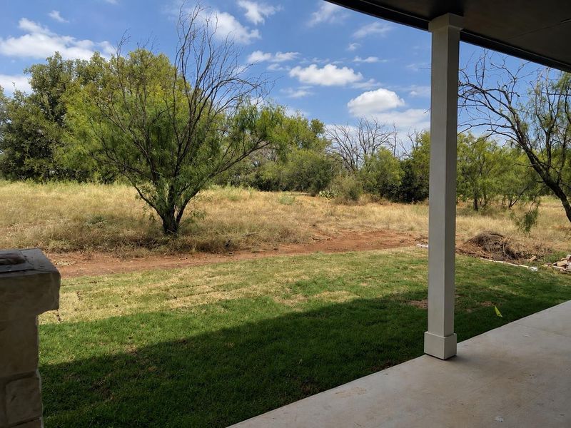 A spacious yard with mature trees offers a serene natural setting for outdoor enjoyment.