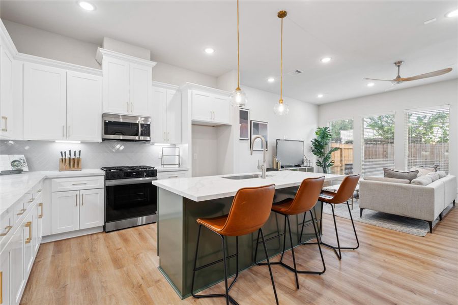 A kitchen that balances statement and simplicity. The accent island draws you in, while layered finishes like brass accents, herringbone tile, and warm lighting create a space that feels both elevated and inviting.