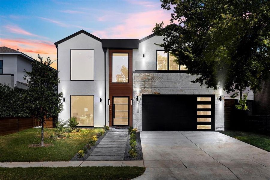 Contemporary home featuring a lawn and a garage