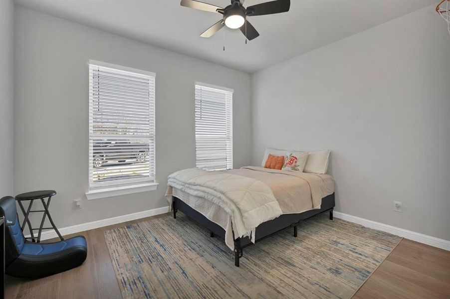 Bedroom featuring a ceiling fan, baseboards, and wood finished floors