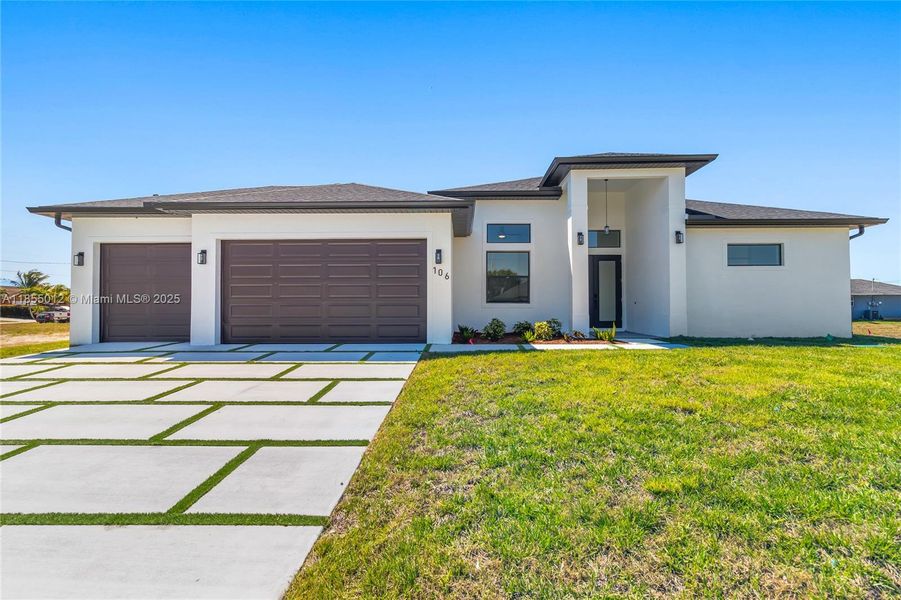 Luxurious home with a front lawn, driveway, and a 3 car garage