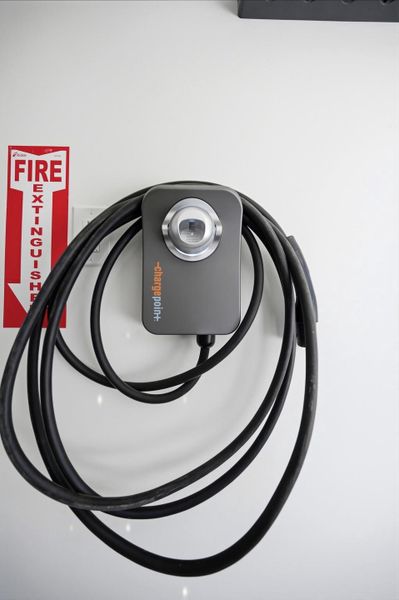 A wall-mounted electric vehicle charging station provides modern convenience in the garage.