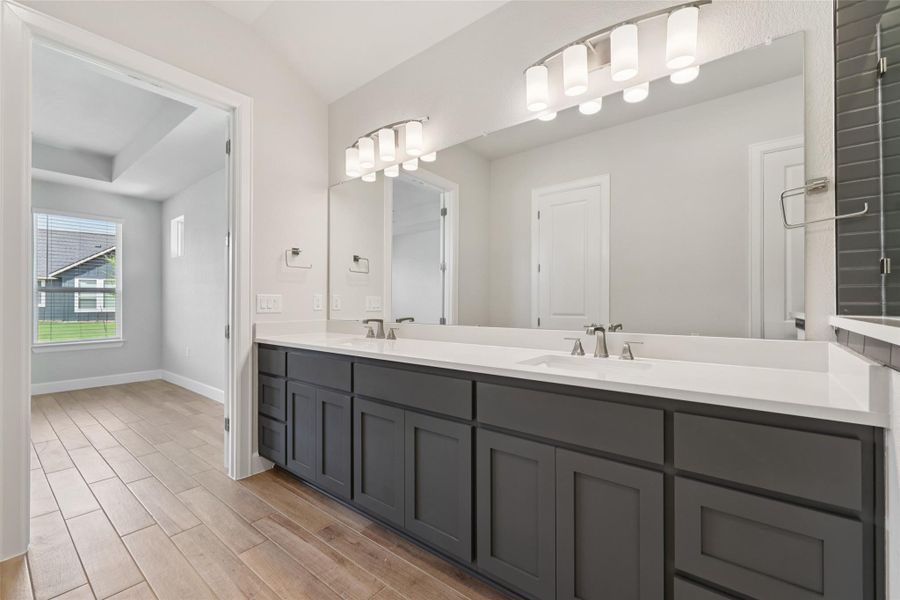 Full bath featuring double vanity and wood finished floors