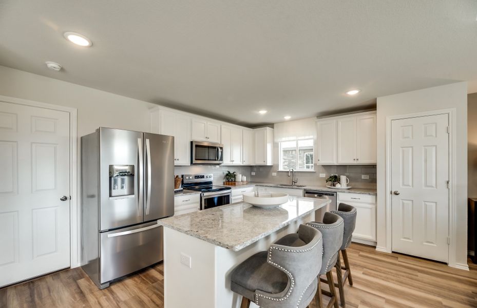 Spacious island kitchen with eat-in bartop and recessed lighting