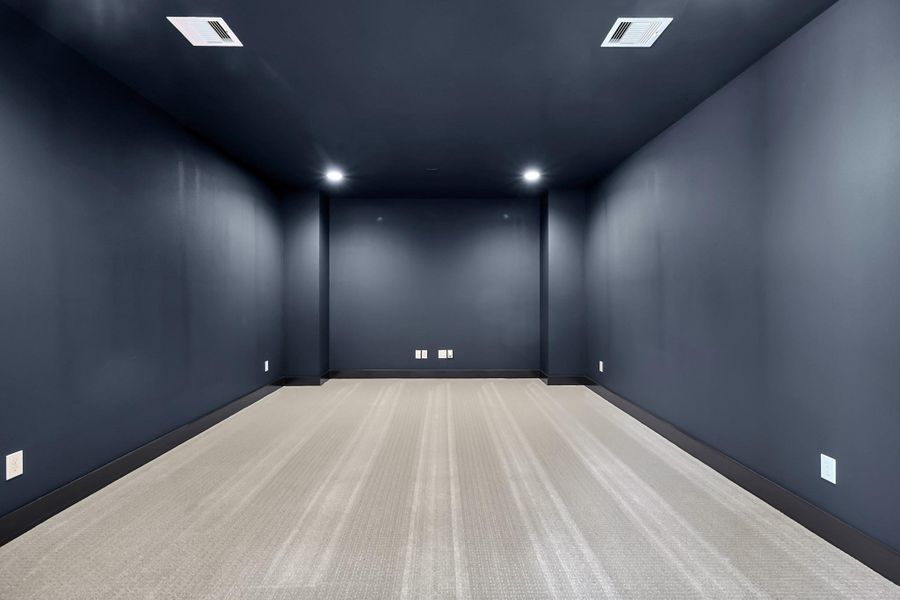 Dark-painted media room designed for an immersive theater experience. Dark-painted media room designed for an immersive theater experience.