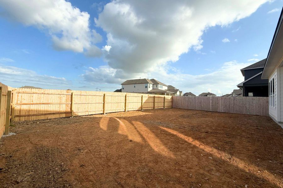 A spacious backyard awaits personalization, enclosed by a privacy fence under an expansive sky. A spacious backyard awaits personalization, enclosed by a privacy fence under an expansive sky.