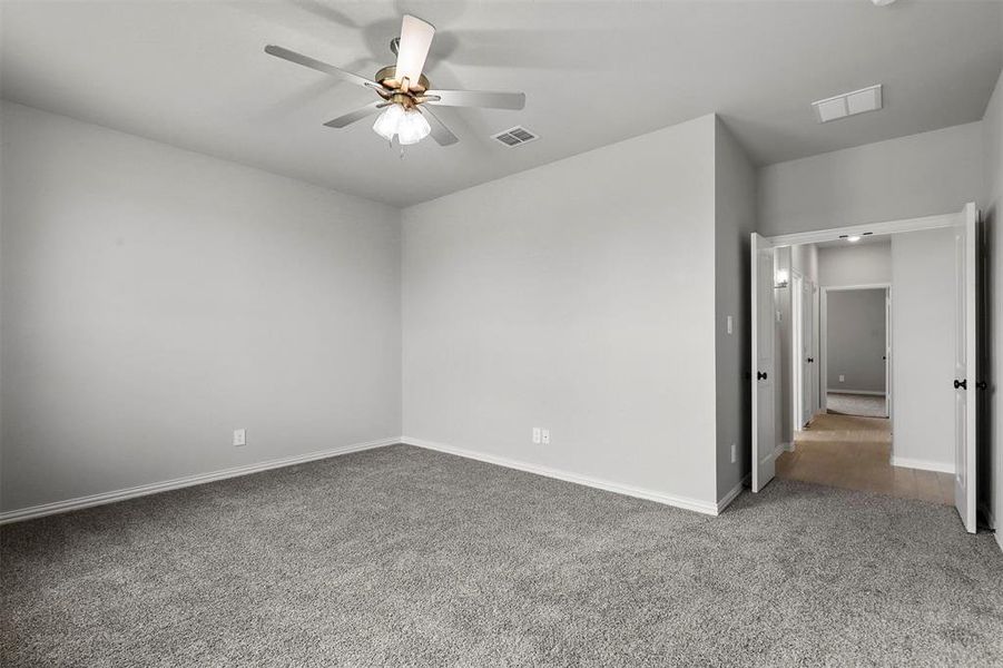 Carpeted empty room featuring ceiling fan