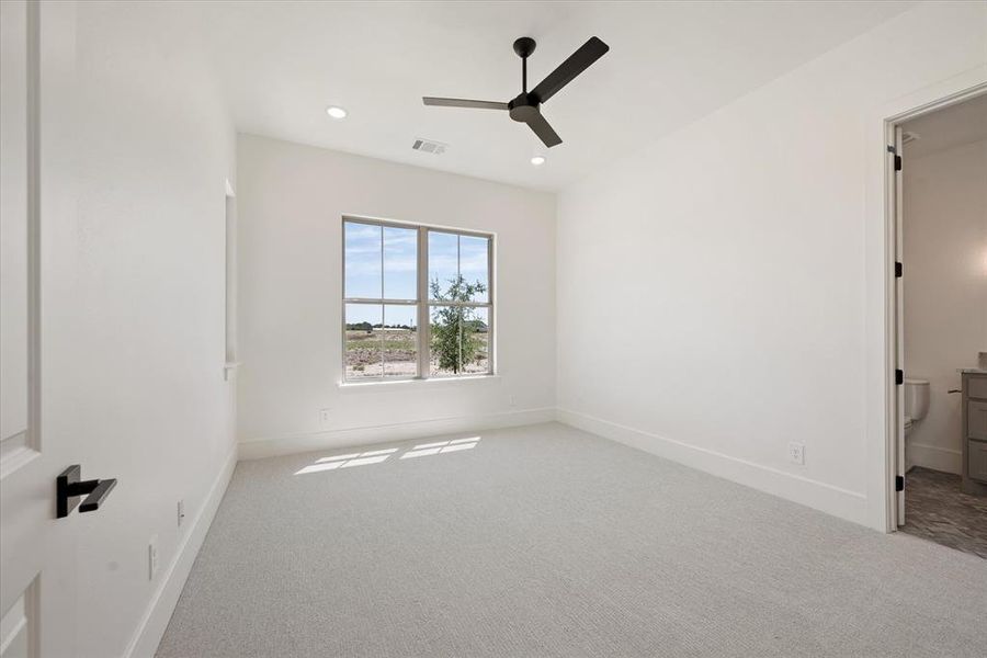 Carpeted empty room with ceiling fan