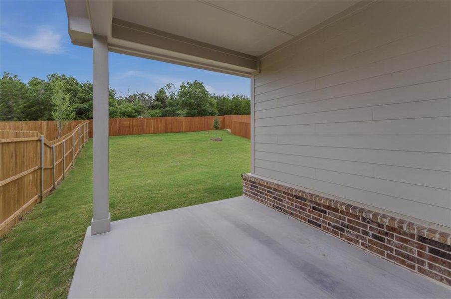 Covered patio with a concrete surface, providing a substantial outdoor living area