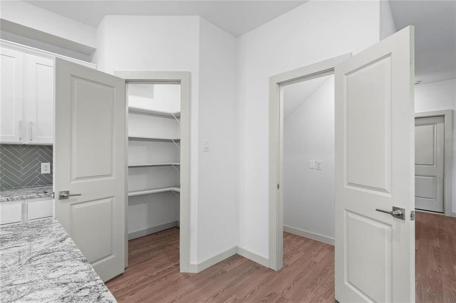 Unfurnished bedroom featuring light wood-style floors and a spacious closet