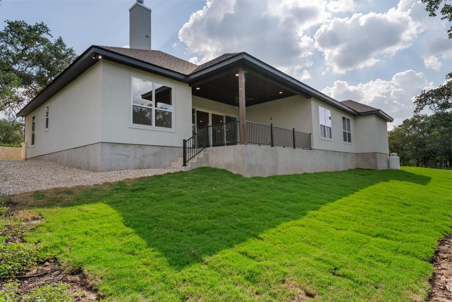 An inviting rear patio overlooks a verdant lawn, ideal for outdoor enjoyment and relaxation.