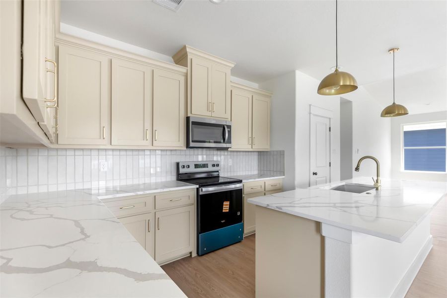 Ample cabinetry with soft-close features and elegant brushed gold fixtures that enhance the kitchen's design.