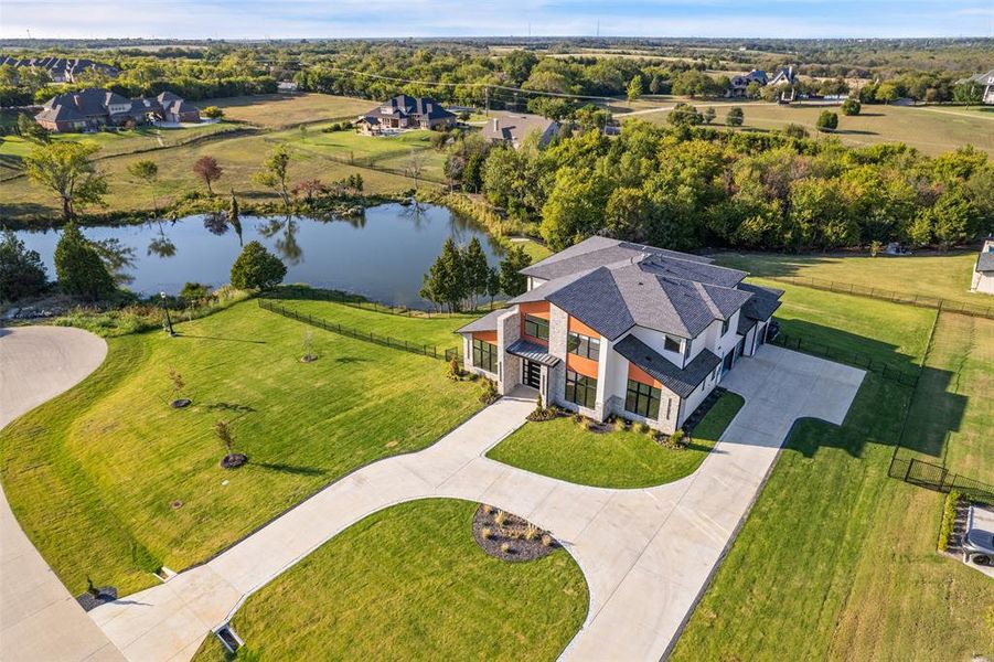 Birds eye view of property with a water view