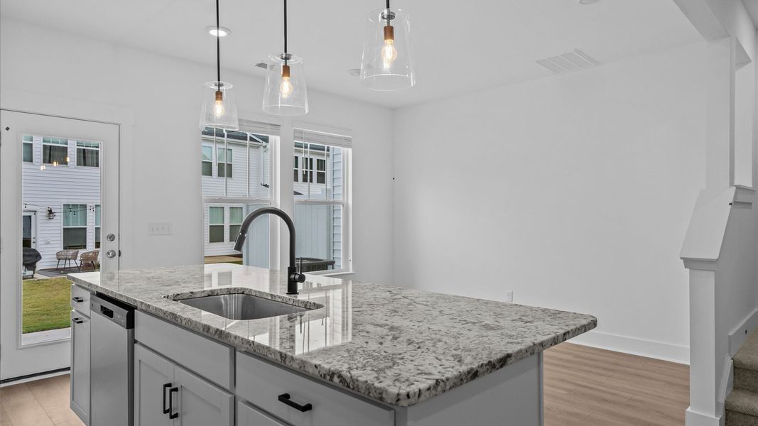 Top-notch kitchen featuring pendant lighting over a statement 9-foot island with seating Top-notch kitchen featuring pendant lighting over a statement 9-foot island with seating