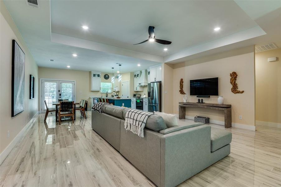 Living room with a tray ceiling, recessed lighting, and ceiling fan Living room with a tray ceiling, recessed lighting, and ceiling fan