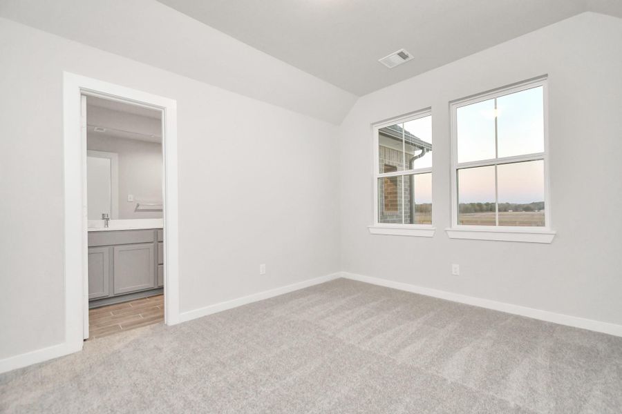 Inviting guest suite adorned with modern charm. The room features elegant 5-panel doors with sleek, contemporary hardware that adds a touch of sophistication. Sink your feet into the plush, fluffy carpet that invites comfort and warmth. Large windows flood the space with an abundance of natural light. Sample photo of completed home with similar floor plan. As-built interior colors and selections may vary. Inviting guest suite adorned with modern charm. The room features elegant 5-panel doors with sleek, contemporary hardware that adds a touch of sophistication. Sink your feet into the plush, fluffy carpet that invites comfort and warmth. Large windows flood the space with an abundance of natural light. Sample photo of completed home with similar floor plan. As-built interior colors and selections may vary.