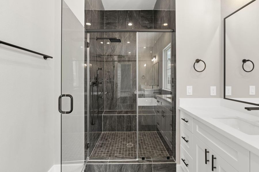 Standing shower with seat and sleek design.