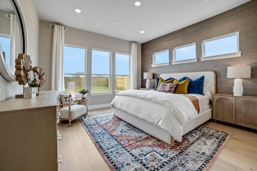 Bedroom with an accent wall, light wood-style floors, and recessed lighting
