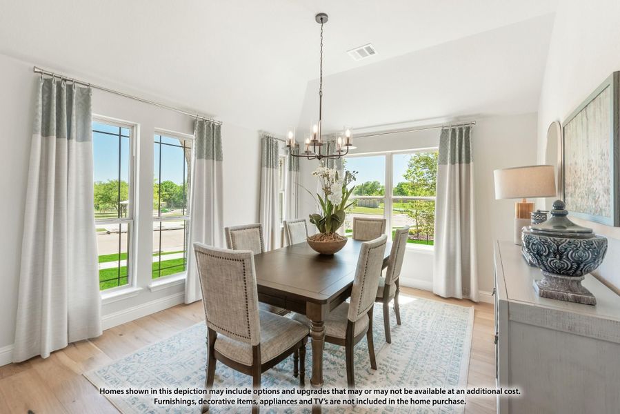 Dining room with dark wood table, upholstered chairs, chandelier, and large windows with natural light Dining room with dark wood table, upholstered chairs, chandelier, and large windows with natural light