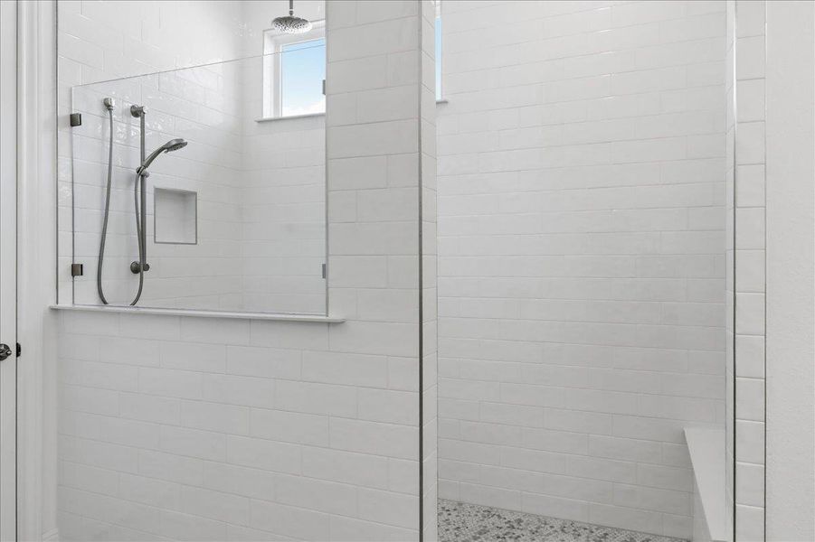 A well-appointed shower space features sleek white subway tile and convenient built-in niches. A well-appointed shower space features sleek white subway tile and convenient built-in niches.