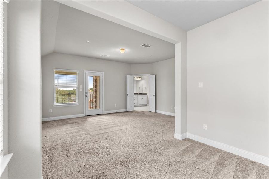 Unfurnished living room featuring lofted ceiling and carpet floors