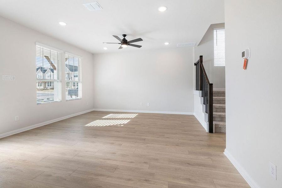 Unfurnished living room featuring a ceiling fan, light wood-style floors, and recessed lighting
