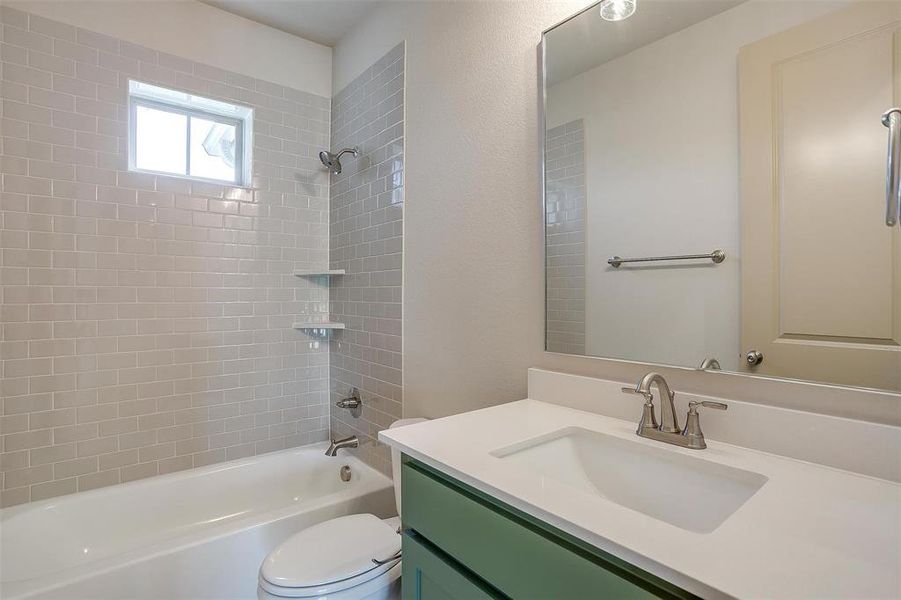 Bathroom with vanity, toilet, and  shower combination