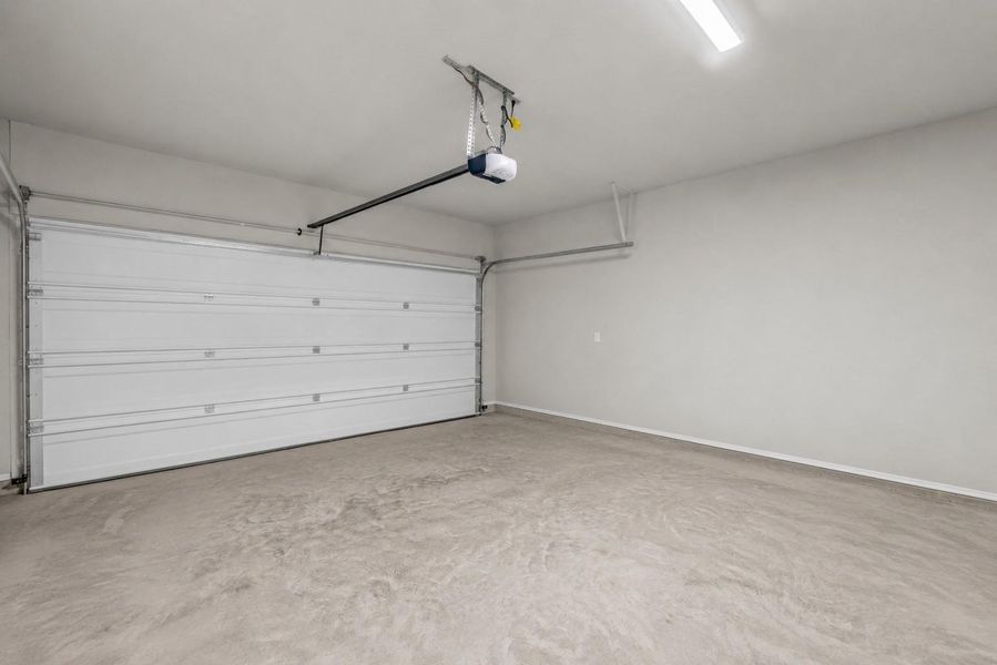 An expansive attached garage provides a clean concrete floor, bright overhead lighting, and an automatic garage door opener. An expansive attached garage provides a clean concrete floor, bright overhead lighting, and an automatic garage door opener.