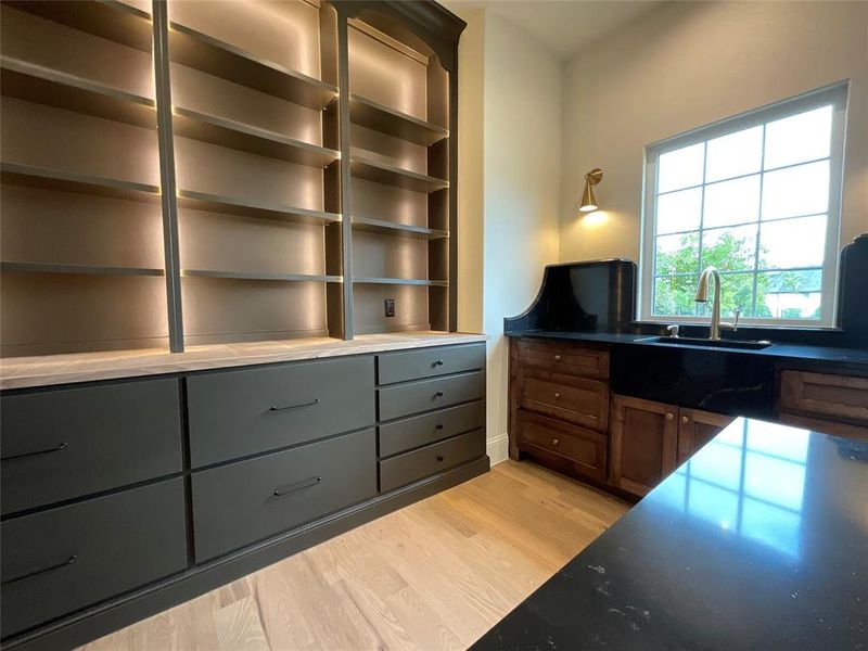 Office area with light hardwood / wood-style floors and sink