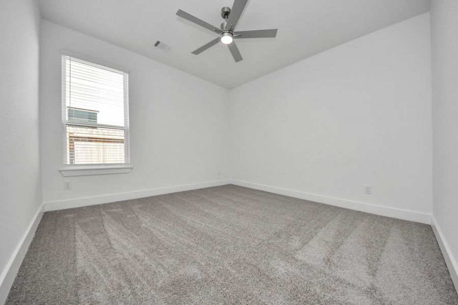 Secondary bedroom features plush carpeting, large windows that let in plenty of natural light, bright paint, and spacious closets.