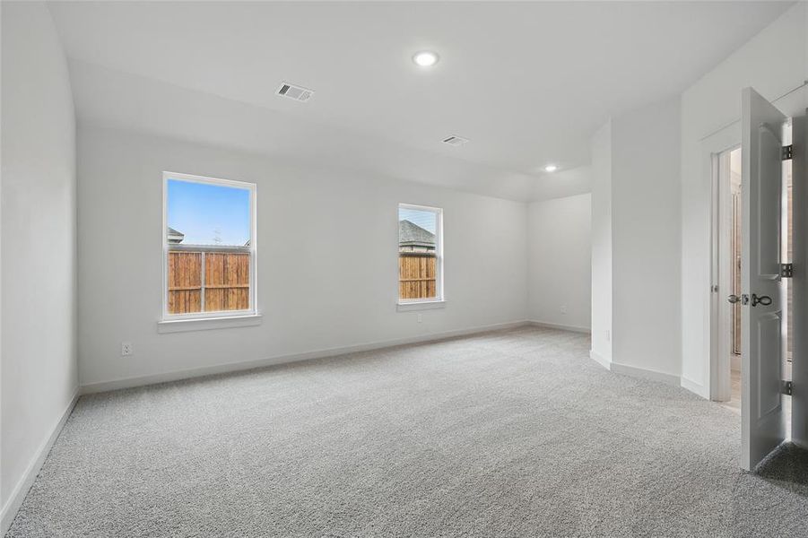Unfurnished room featuring light carpet, healthy amount of natural light, and recessed lighting Unfurnished room featuring light carpet, healthy amount of natural light, and recessed lighting