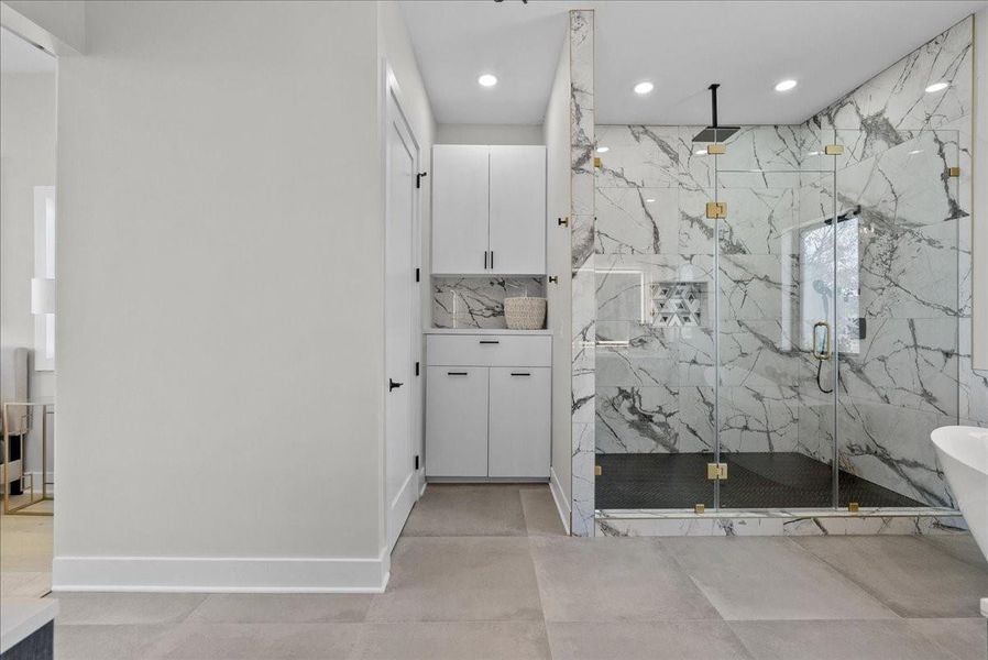 The oversized walk-in shower features multiple showerheads, including a soothing rain shower, with porcelain tile carried all the way to the ceiling — pure spa-level luxury. The oversized walk-in shower features multiple showerheads, including a soothing rain shower, with porcelain tile carried all the way to the ceiling — pure spa-level luxury.