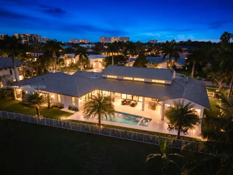 Single-story residence featuring a metal roof, clerestory windows, an expansive covered patio, a rectangular swimming pool, and a fenced perimeter Single-story residence featuring a metal roof, clerestory windows, an expansive covered patio, a rectangular swimming pool, and a fenced perimeter