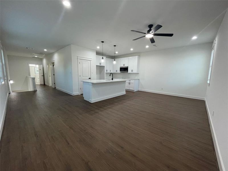 Unfurnished living room featuring recessed lighting, dark wood-type flooring, and a ceiling fan