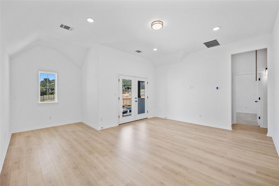 Empty bonus/flex room with vaulted ceiling, light wood finished floors, and recessed lighting