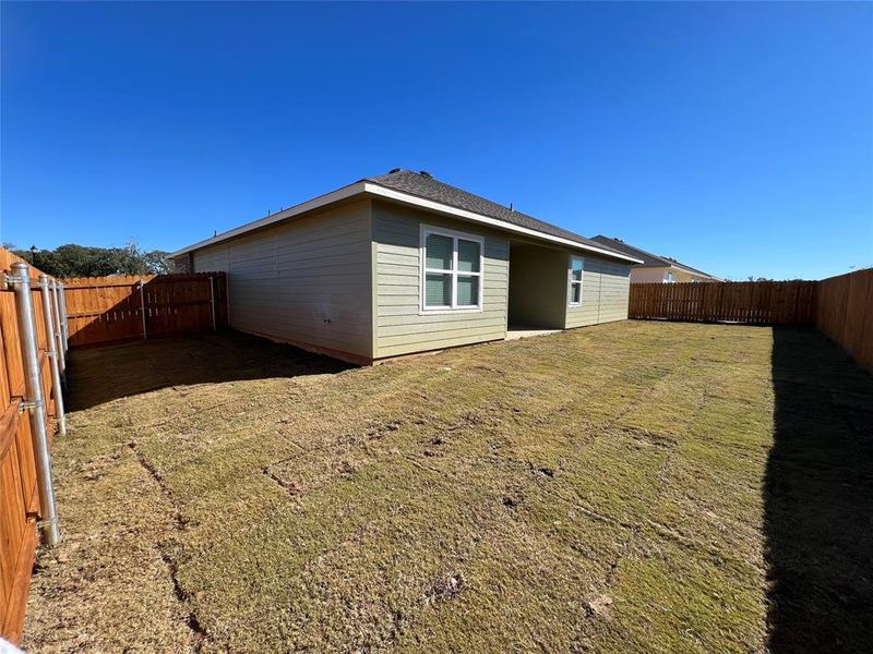 Rear view of property with a lawn