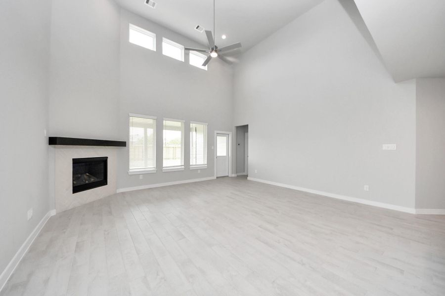 Welcome family and guests to your charming living room! With its high ceilings, recessed lighting, ceiling fan, custom paint, beautiful flooring, and large windows that let in abundant natural light, this room is perfect for gatherings. Sample photo of completed home with similar floor plan. Actual colors and selections may vary. Welcome family and guests to your charming living room! With its high ceilings, recessed lighting, ceiling fan, custom paint, beautiful flooring, and large windows that let in abundant natural light, this room is perfect for gatherings. Sample photo of completed home with similar floor plan. Actual colors and selections may vary.