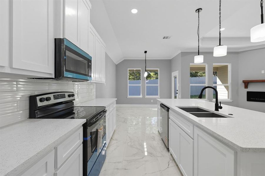 Kitchen featuring stainless steel appliances, white cabinetry, pendant lighting, light marble finish floors, and recessed lighting Kitchen featuring stainless steel appliances, white cabinetry, pendant lighting, light marble finish floors, and recessed lighting