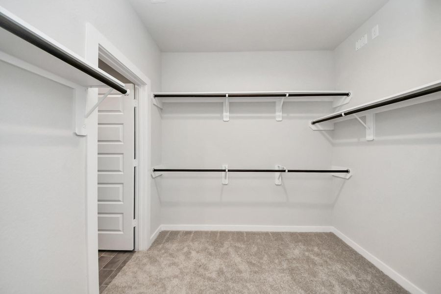 Walk-in closet that epitomizes luxury and practicality. This generously sized space features built-in shelving, offering abundant room for impeccable organization. High ceilings and recessed lighting create a bright and welcoming ambiance. Sample photo of completed home with similar floor plan. Actual colors and selections may vary. Walk-in closet that epitomizes luxury and practicality. This generously sized space features built-in shelving, offering abundant room for impeccable organization. High ceilings and recessed lighting create a bright and welcoming ambiance. Sample photo of completed home with similar floor plan. Actual colors and selections may vary.