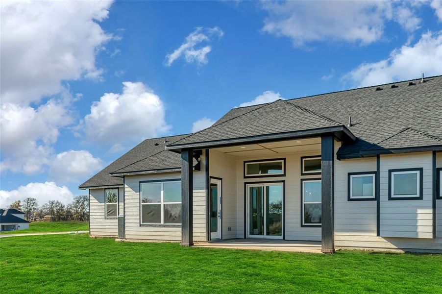 Rear view of property with a yard and a patio