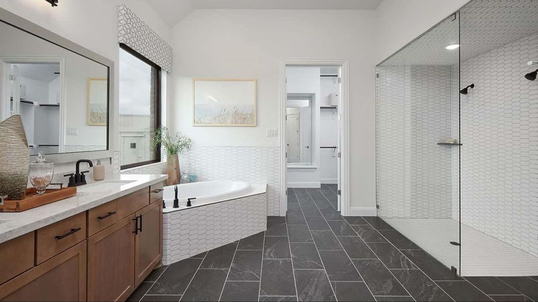 Full bathroom featuring a bath, walk in shower, double vanity, a spacious closet, and vaulted ceiling